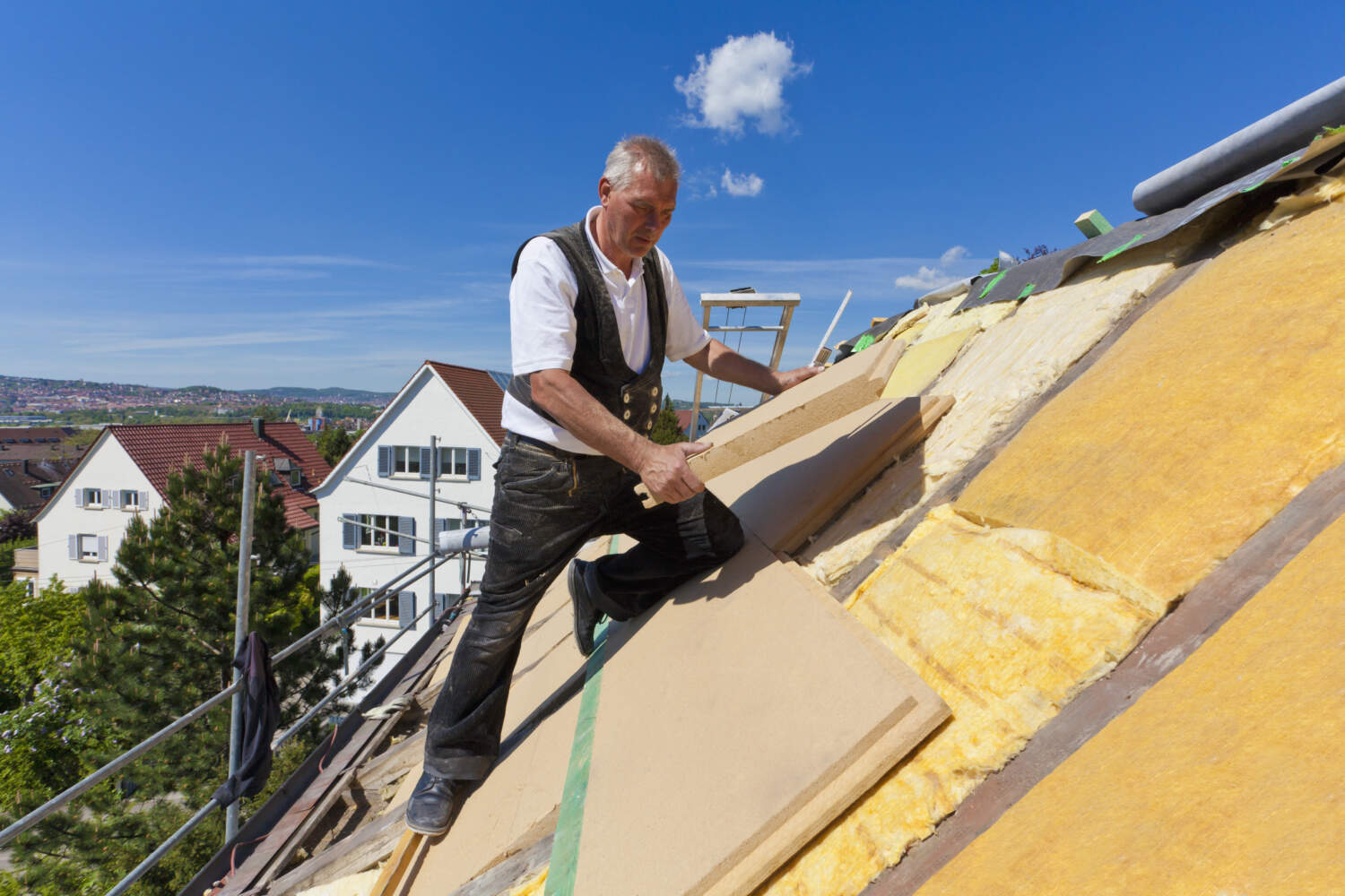 Photo d'un homme entrain d'isoler une toiture par l'extérieur