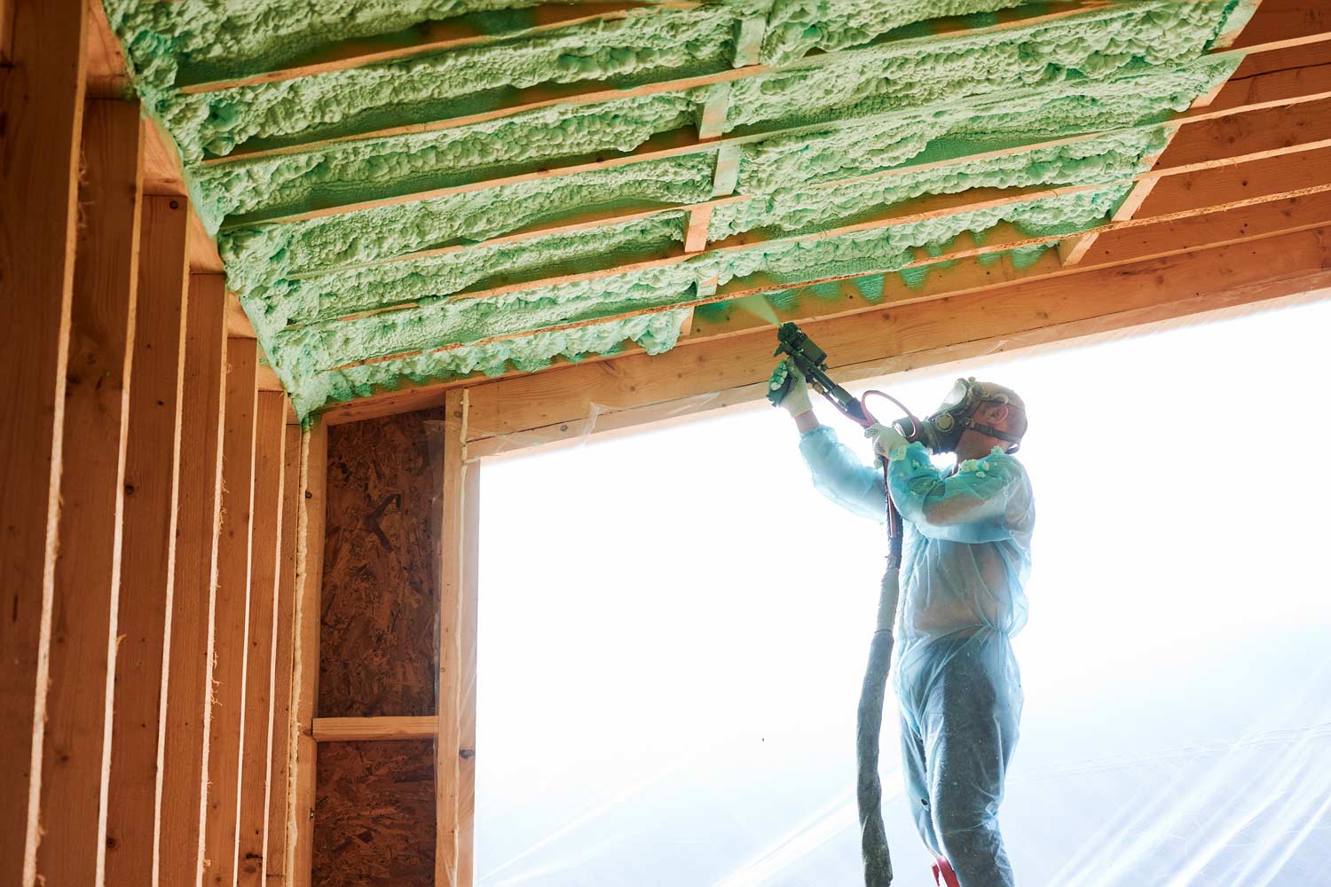 Photo d'un homme entrain de réaliser l'isolation intérieure d'une maison
